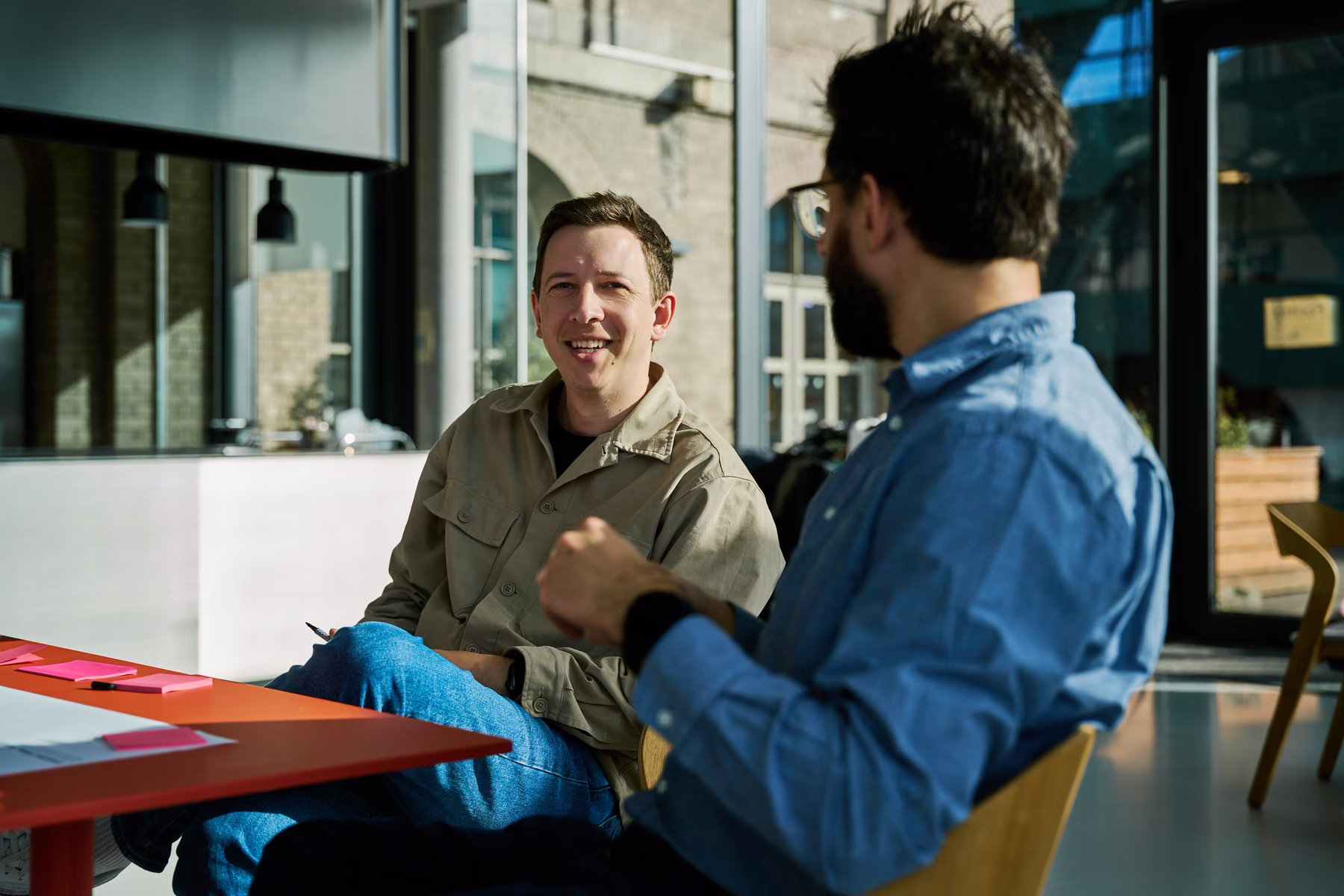 Zwei Kollegen im Gespräch an einem Arbeitstisch im FutureFoodCo Space in Berlin